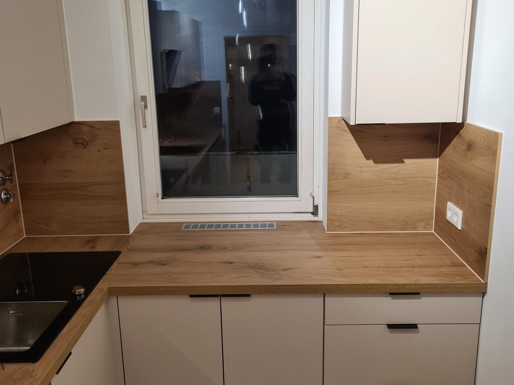 Kuchnia po remoncie - biała zabudowa, drewniany blat i sprzęt AGD. (3)